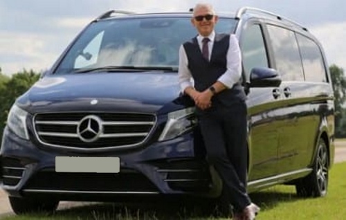 driver chauffeur standing by luxury car